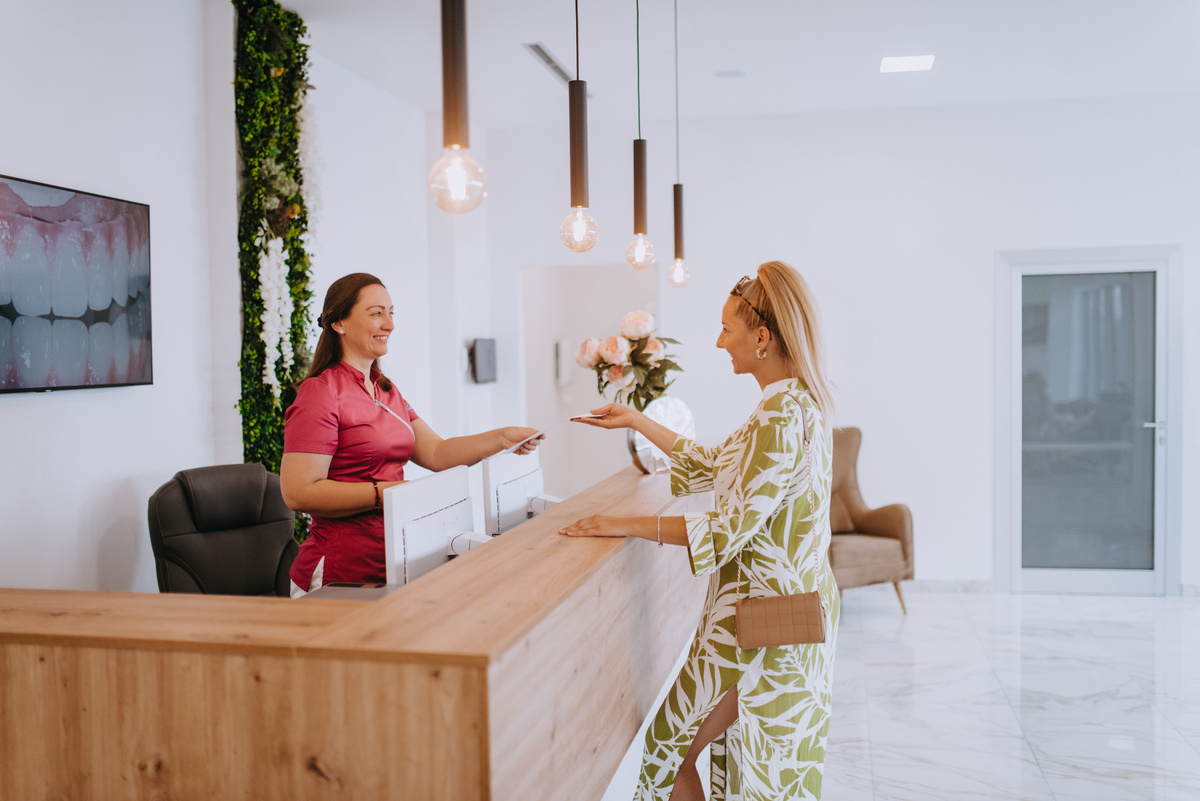 Beautiful blonde shakes hands with an employee of the dental office after the agreed dental examination